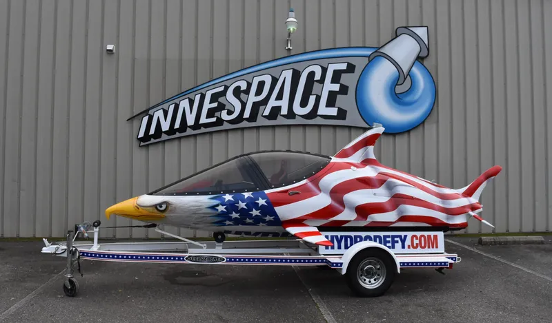 Slide: The Image of Seabreacher X, Y, Z 2025 model with American flag design outside Innespace facility. - 18