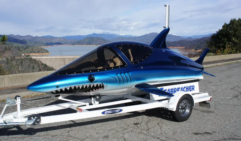 Slide: The Image of A 2025 Seabreacher X model, shark-themed watercraft on a trailer by a scenic lake. - 34