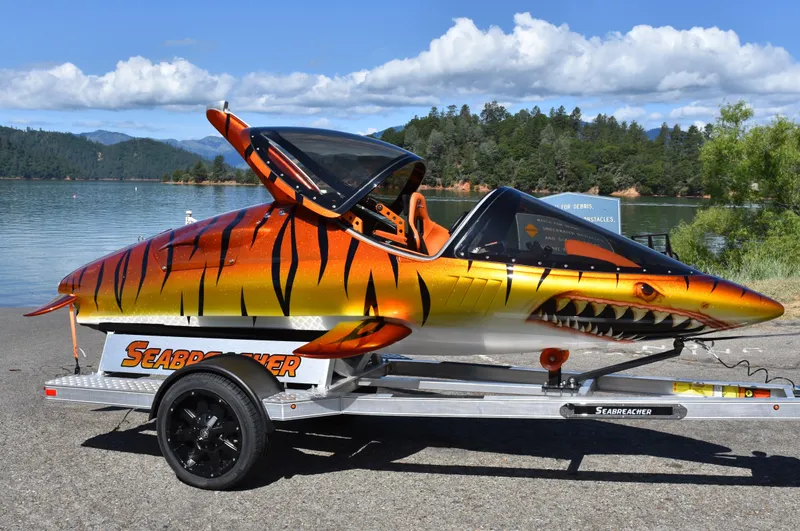 Slide: The Image of 2025 Seabreacher X, Y, Z model with shark design on a trailer by a lake. - 45