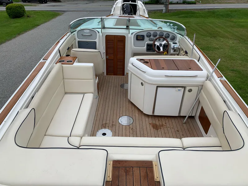 Slide: The Image of 2005 Chris-Craft Corsair 28 boat interior with beige seating and wooden accents. - 12