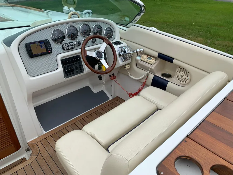 Slide: The Image of 2005 Chris-Craft Corsair 28 boat interior with beige seating and classic dashboard. - 13