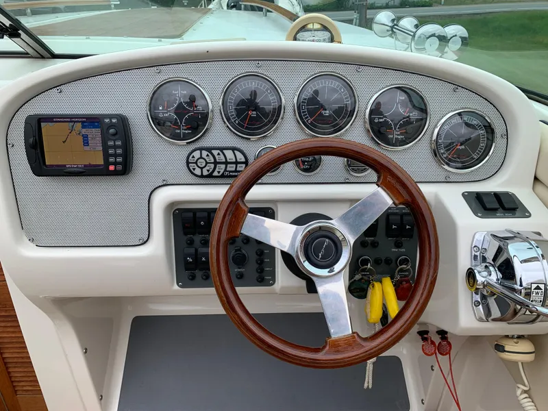 Slide: The Image of 2005 Chris-Craft Corsair 28 dashboard with gauges, GPS, and wooden steering wheel. - 14