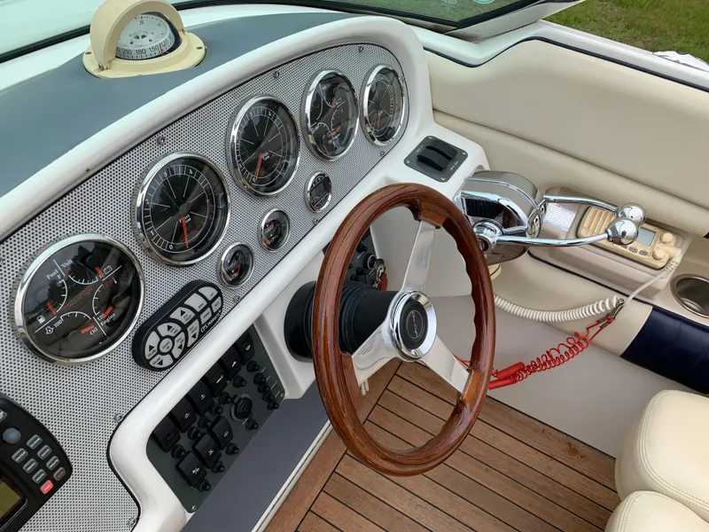 Slide: The Image of 2005 Chris-Craft Corsair 28 dashboard with wood steering wheel and classic gauges. - 18