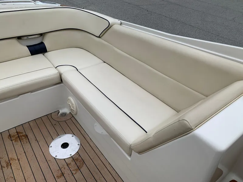 Slide: The Image of 2005 Chris-Craft Corsair 28 boat interior with beige leather seating and wooden deck. - 21