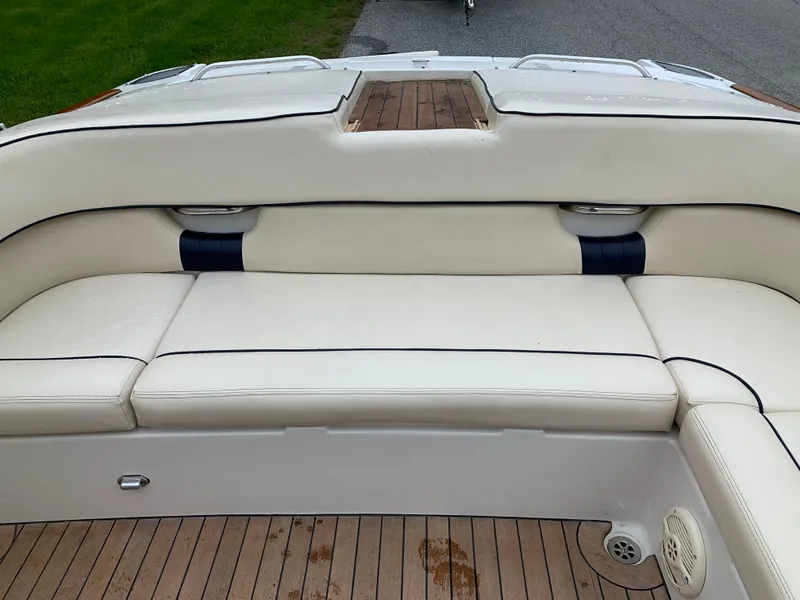 Slide: The Image of 2005 Chris-Craft Corsair 28 boat interior with white leather seating and wooden flooring. - 22