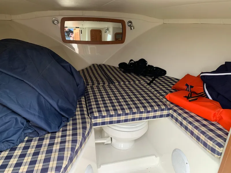 Slide: The Image of 2005 Chris-Craft Corsair 28 cabin interior with plaid cushions and life jackets. - 28