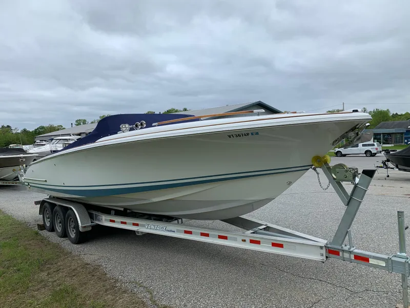 Slide: The Image of 2005 Chris-Craft Corsair 28 boat on trailer, parked outdoors under cloudy sky. - 3
