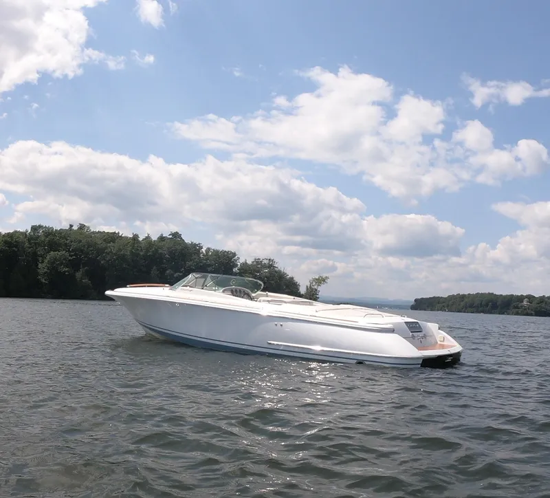 Slide: The Image of 2006 Chris-Craft Corsair 28 boat on a lake under a partly cloudy sky. - 34