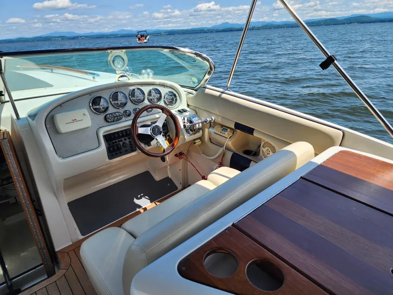 Slide: The Image of 2006 Chris-Craft Corsair 28 boat interior with steering wheel and dashboard on open water. - 36