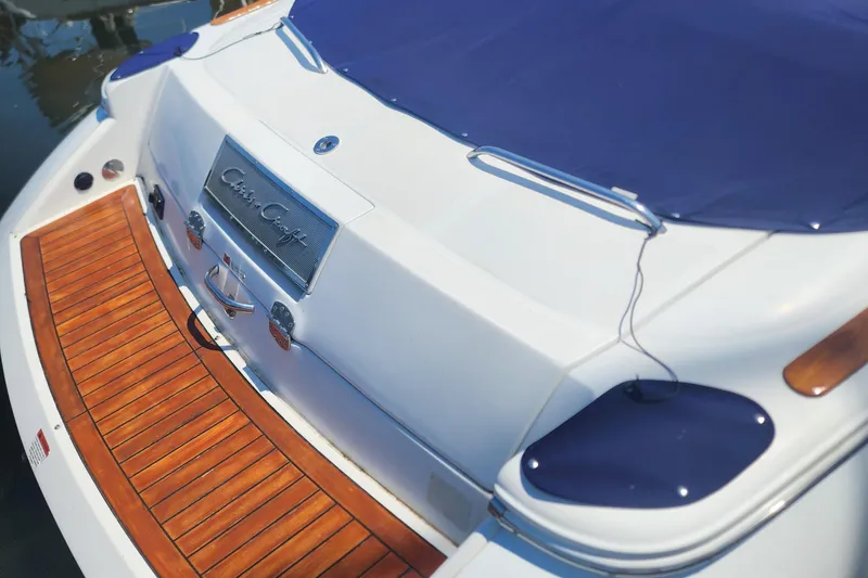 Slide: The Image of 2006 Chris-Craft Corsair 28 boat with blue cover and wooden deck. - 49