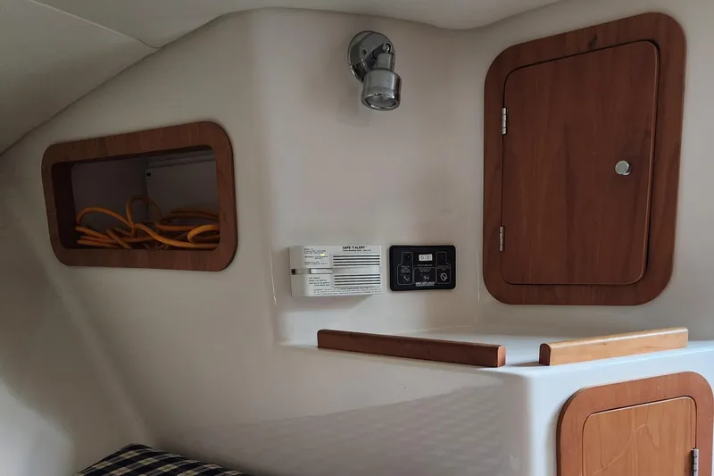 Slide: The Image of 2006 Chris-Craft Corsair 28 cabin interior with wood accents and storage compartments. - 51