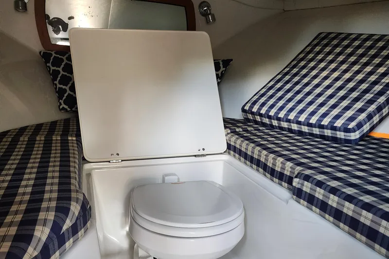 Slide: The Image of 2006 Chris-Craft Corsair 28 cabin interior with plaid cushions and compact toilet. - 52