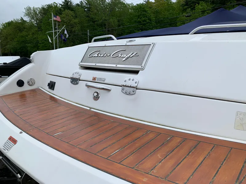 Slide: The Image of 2005 Chris-Craft Corsair 28 boat with wooden deck and logo, docked outdoors. - 6