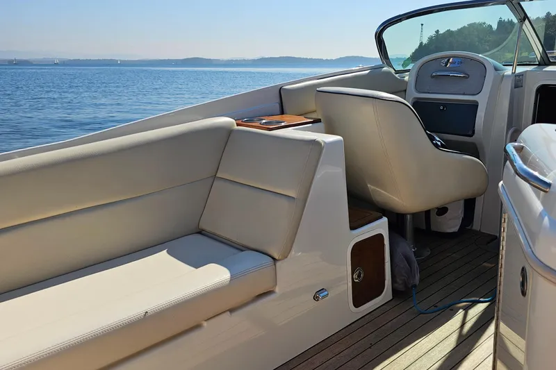 Slide: The Image of 2006 Chris-Craft Corsair 28 boat interior with beige seating, on a sunny day by the water. - 61