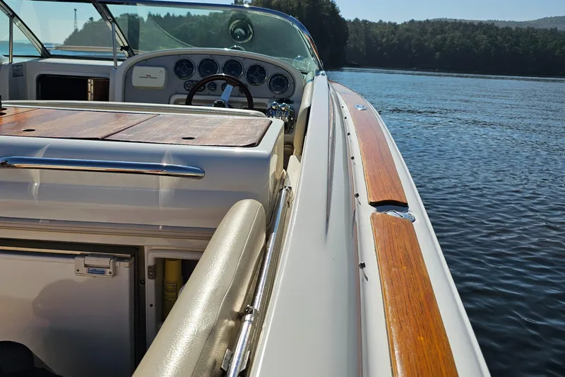 Slide: The Image of 2006 Chris-Craft Corsair 28 boat interior with wooden accents on a calm lake. - 63
