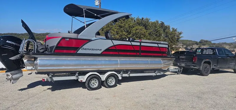 Slide: The Image of 2023 Berkshire 25RFX STS 3.0 pontoon boat on trailer, towed by a truck. - 2