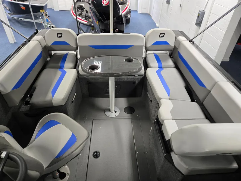 Slide: The Image of 2025 Princecraft Sport 188 boat interior with gray and blue seating, central table, and modern design. - 12