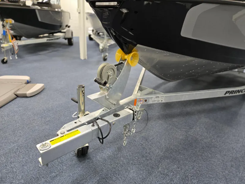 Slide: The Image of 2025 Princecraft Sport 188 boat trailer with hitch and winch in showroom. - 2