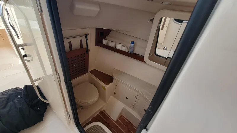Slide: The Image of 2021 Grady-White Freedom 335 boat interior bathroom with toilet and storage shelves. - 22