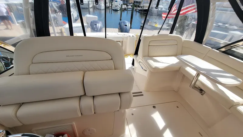 Slide: The Image of 2021 Grady-White Freedom 335 boat interior with beige seating and marina view. - 24