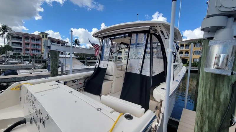 Slide: The Image of 2021 Grady-White Freedom 335 boat docked at marina under blue sky. - 7