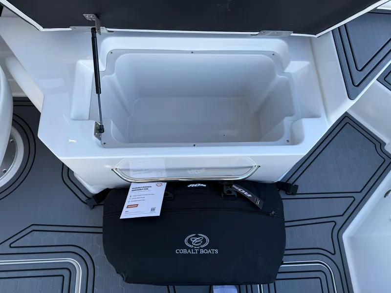 Slide: The Image of Open storage compartment on 2025 Cobalt R6 Surf boat with branded bag. - 37