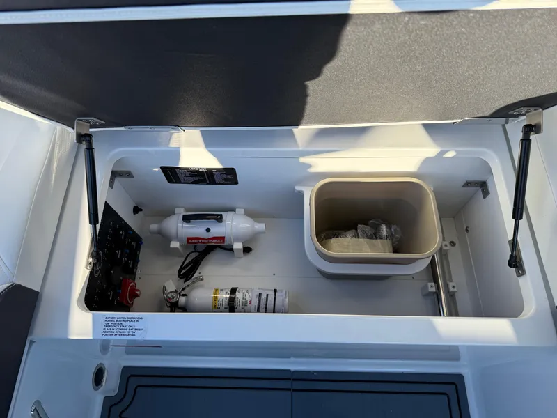 Slide: The Image of 2025 Cobalt R6 Surf storage compartment with safety equipment and storage bin. - 38
