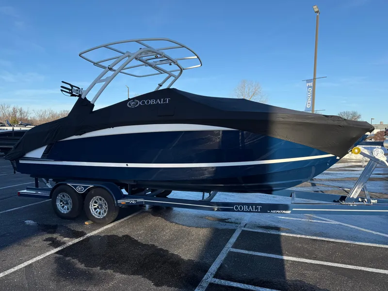 Slide: The Image of 2025 Cobalt R6 Surf boat on trailer, covered, parked in lot. - 49