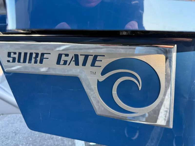 Slide: The Image of 2025 Cobalt R6 Surf boat with Surf Gate logo on blue exterior. - 6