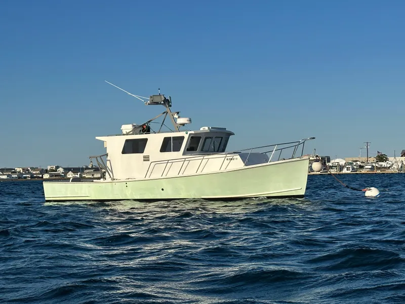 Slide: The Image of 1988 Young Brothers 40 boat on calm water under clear blue sky. - 0