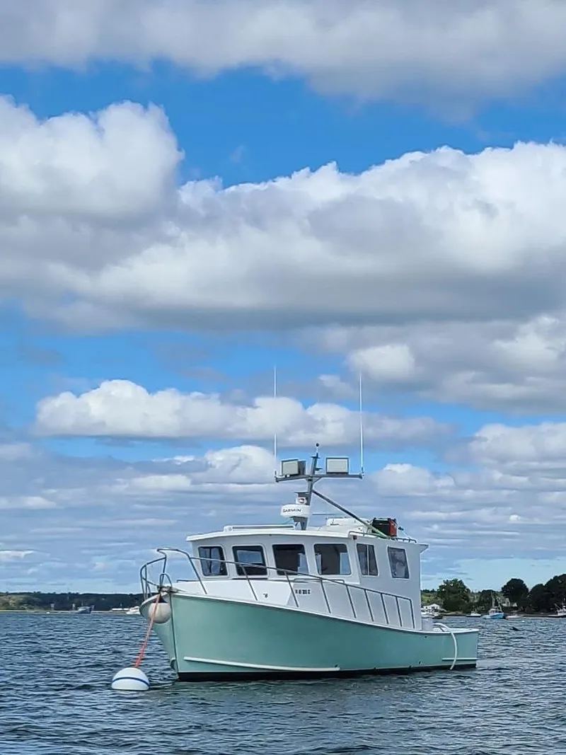Slide: The Image of 1988 Young Brothers 40 boat on calm water under a partly cloudy sky. - 1