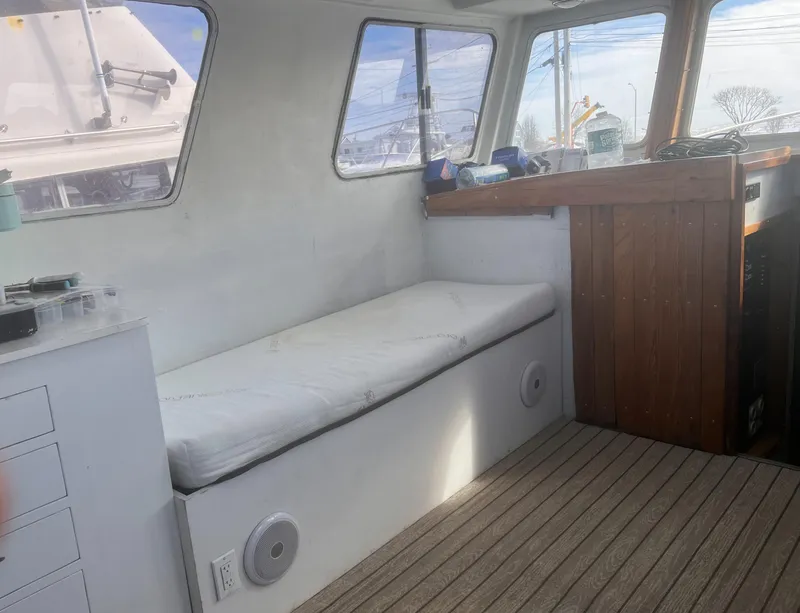 Slide: The Image of Interior of 1988 Young Brothers 40 boat with cushioned seating and wooden accents. - 11