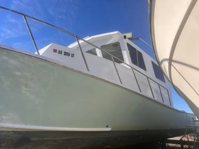 Slide: The Image of 1988 Young Brothers 40 boat with white hull, docked under clear blue sky. - 5
