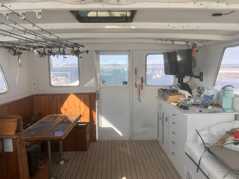 Slide: The Image of Interior of 1988 Young Brothers 40 boat with fishing rods and wooden furnishings. - 9