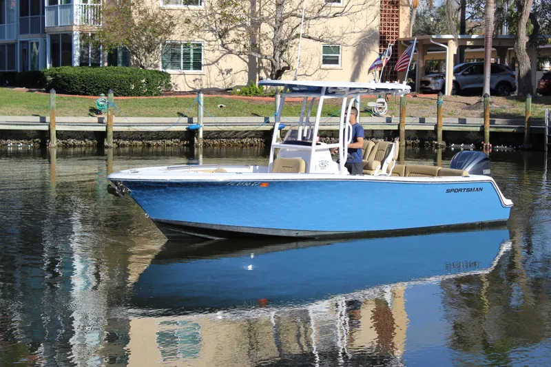 Slide: The Image of 2023 Sportsman Heritage 231 Center Console boat on calm water near a dock. - 0