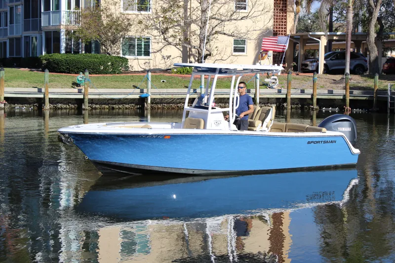 Slide: The Image of 2023 Sportsman Heritage 231 Center Console boat on calm water near dock. - 1