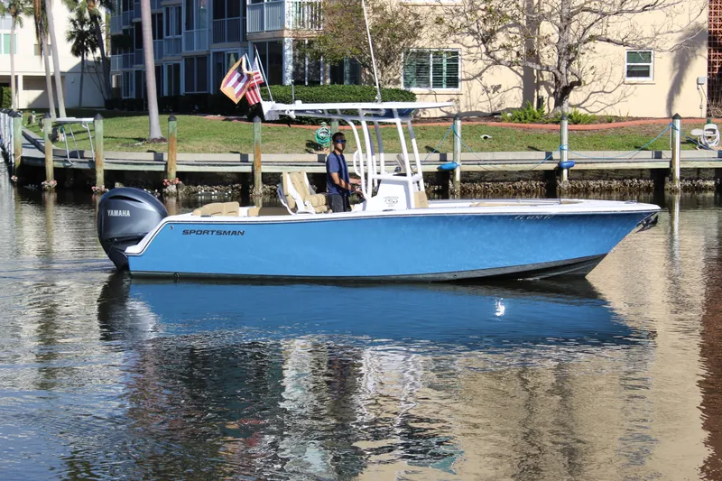 Slide: The Image of 2023 Sportsman Heritage 231 Center Console boat on calm water near docks. - 10