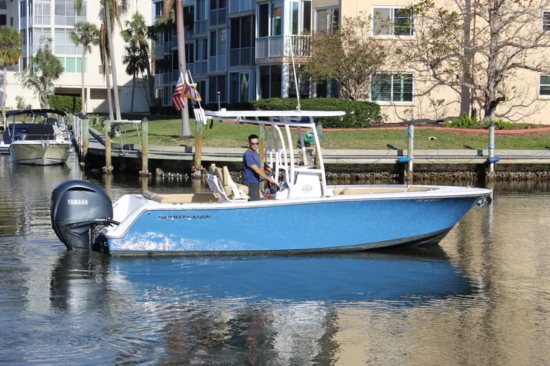 Slide: The Image of 2023 Sportsman Heritage 231 Center Console boat on calm water near docks. - 11