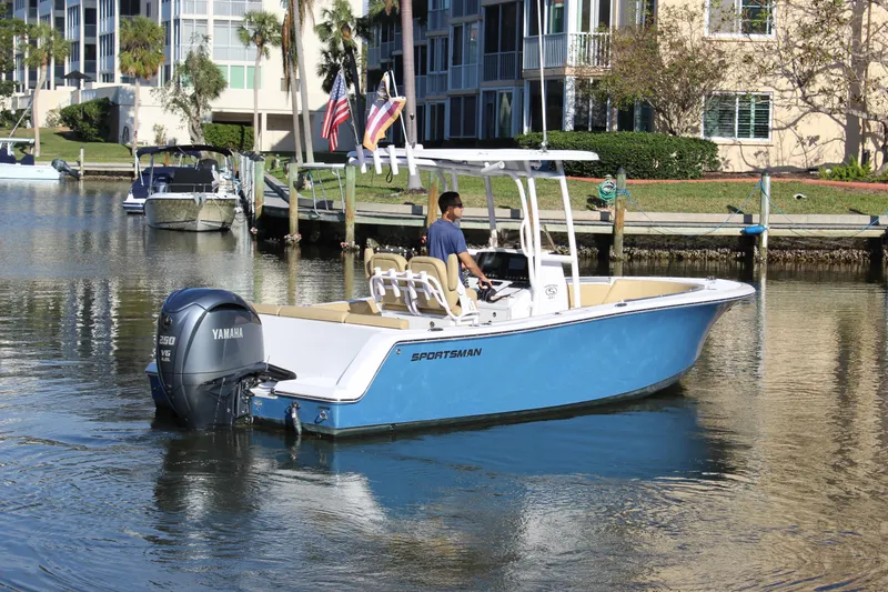 Slide: The Image of 2023 Sportsman Heritage 231 Center Console boat on calm water near waterfront buildings. - 12