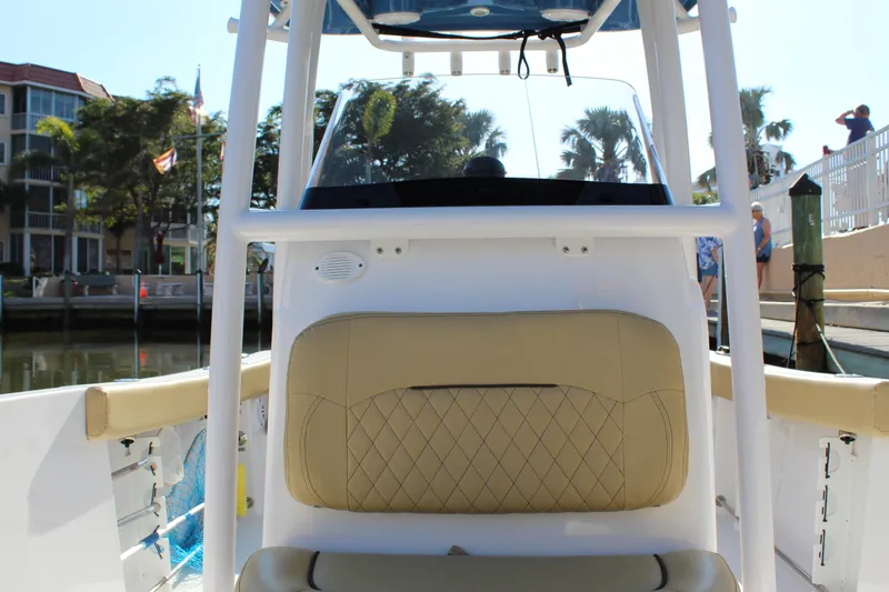 Slide: The Image of 2023 Sportsman Heritage 231 Center Console boat interior with beige seating at a marina. - 25