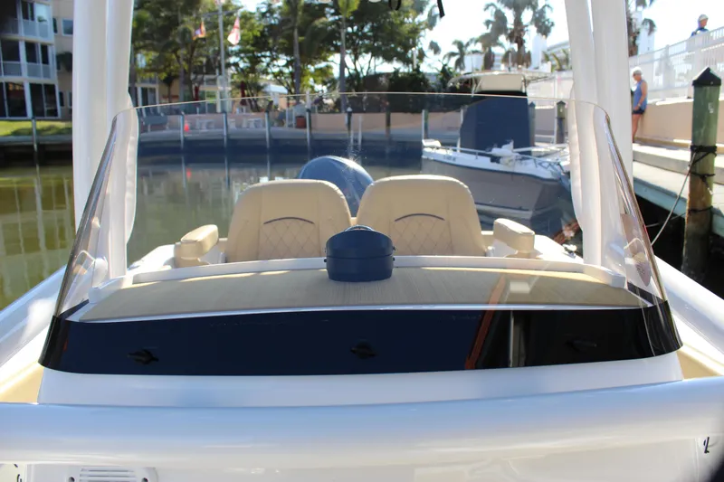 Slide: The Image of 2023 Sportsman Heritage 231 Center Console boat docked, featuring dual seats and clear windshield. - 26
