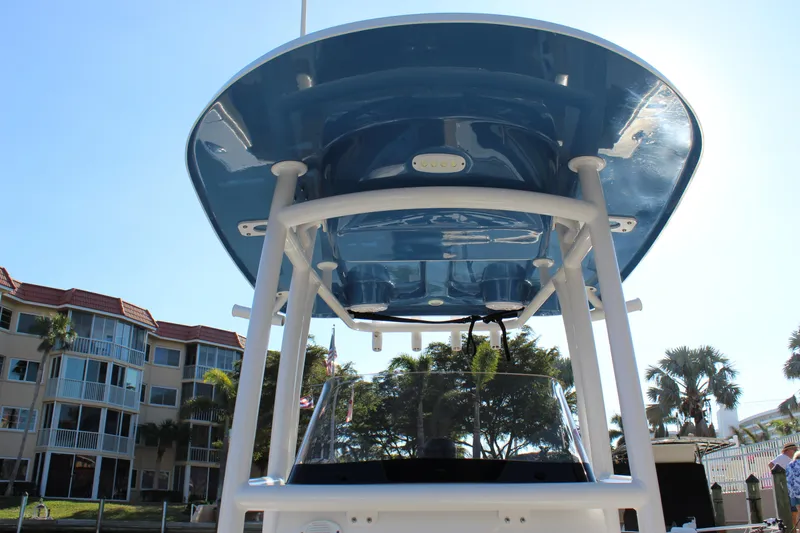 Slide: The Image of 2023 Sportsman Heritage 231 Center Console boat with blue T-top, docked near buildings. - 28