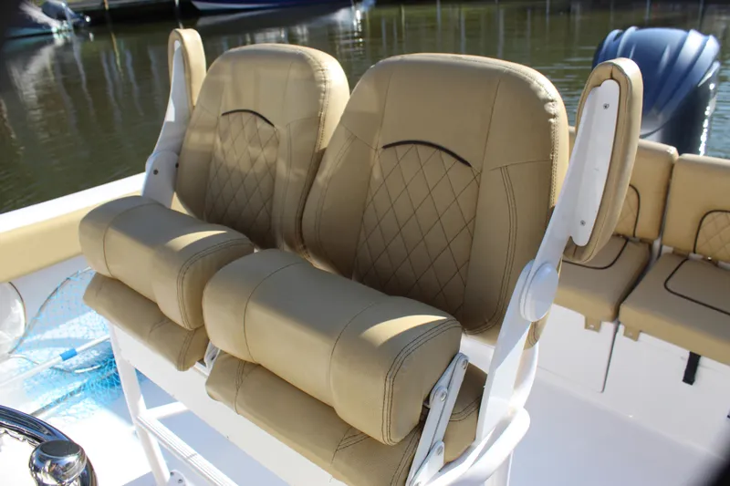 Slide: The Image of 2023 Sportsman Heritage 231 Center Console boat seats, tan upholstery, diamond stitching, docked. - 30