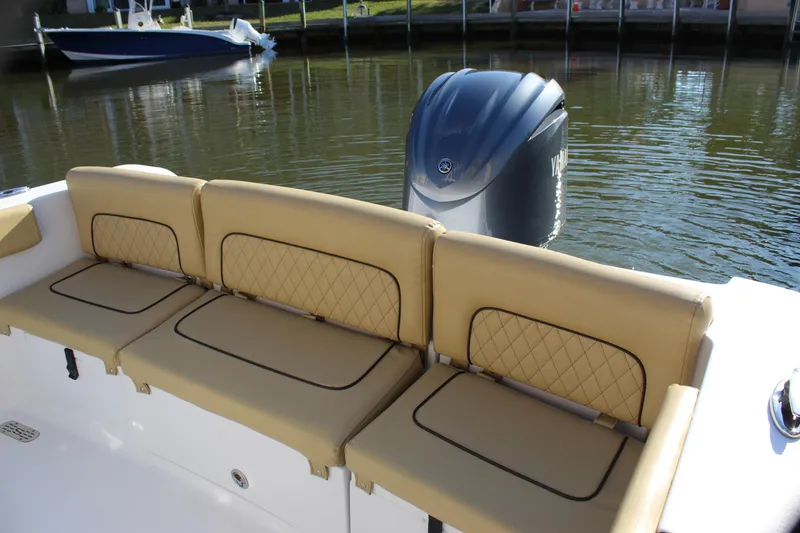 Slide: The Image of 2023 Sportsman Heritage 231 Center Console boat with tan seating and outboard motor. - 38