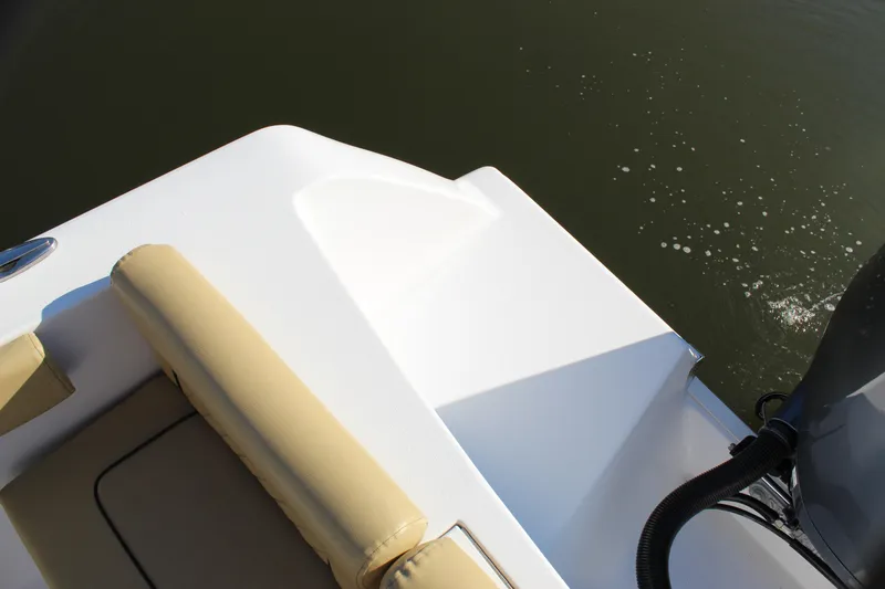 Slide: The Image of 2023 Sportsman Heritage 231 Center Console boat, beige seating, white deck, on water. - 40