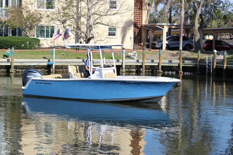 Slide: The Image of 2023 Sportsman Heritage 231 Center Console boat on calm water near a dock. - 9