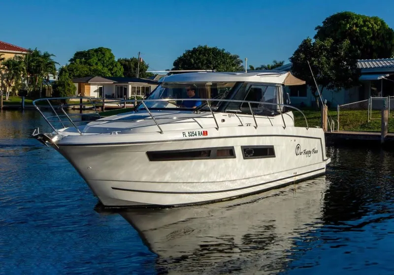 Slide: The Image of 2016 Jeanneau Merry Fisher 855 boat cruising on a calm waterway. - 2