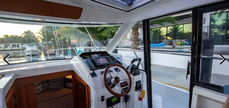 Slide: The Image of Interior view of 2016 Jeanneau Merry Fisher 855 boat cockpit with steering wheel and controls. - 21