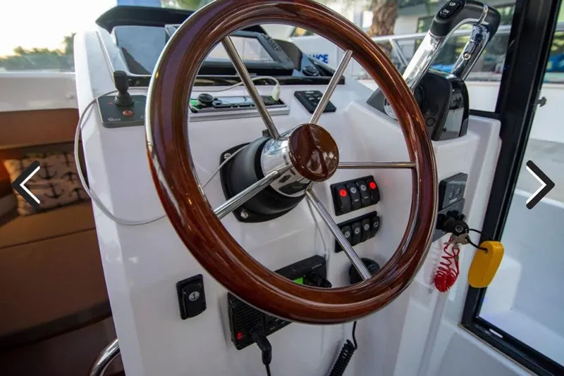 Slide: The Image of Steering wheel of 2016 Jeanneau Merry Fisher 855 boat with control panel. - 27