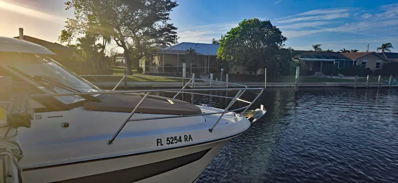 Slide: The Image of 2016 Jeanneau Merry Fisher 855 docked by a serene waterfront at sunset. - 33